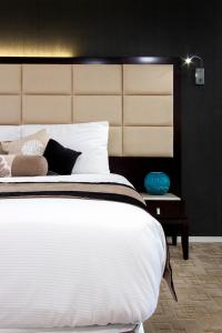 奥克兰VR皇后街套房酒店的卧室配有一张大白色的床和大床头板