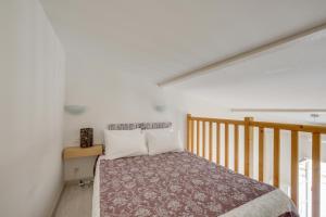 圣艾米隆罗吉斯安德奥一室公寓酒店的一间卧室设有一张床和木制楼梯。