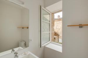 圣艾米隆罗吉斯安德奥一室公寓酒店的白色的浴室设有窗户和水槽