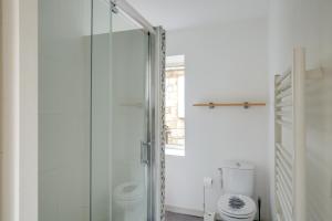 圣艾米隆罗吉斯安德奥一室公寓酒店的浴室设有玻璃淋浴间和卫生间