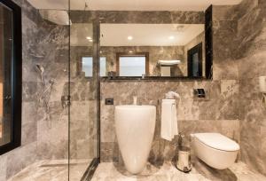 伊兹密尔珍妮瓦酒店的一间带卫生间和玻璃淋浴间的浴室