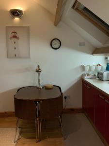 沃金顿Dove Cottage (Annex)的厨房配有桌子和墙上的时钟
