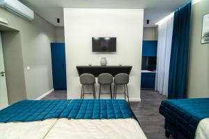 萨拉热窝Apartments Azzurro Sarajevo的一间客房配有两张床和一张桌子及两把椅子