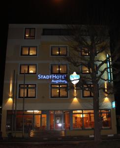 奥格斯堡奥格斯堡斯塔德特酒店的一座建筑,上面标有星星酒店在晚上的标志