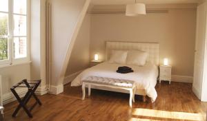 BrinayLe château de la brosse Chambres d'hôtes的一间卧室配有一张白色床、两盏灯和两张桌子