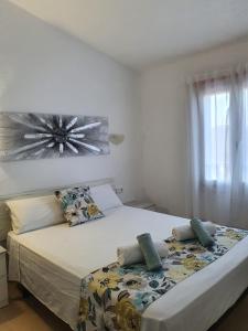 卡拉加尔达纳Garbí & Xaloc apartamentos的一间卧室设有两张床和窗户。