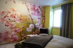 萨尔堡Ferienwohnung Landidyll的一间卧室配有一张床,一棵树上种着粉红色的花朵