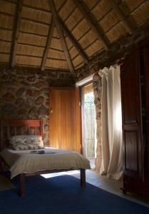 塔巴津比Griffons Bush Camp的一间卧室设有一张床和石墙