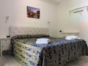 里米尼Hotel Marittima的一间卧室配有一张床,上面有两条毛巾