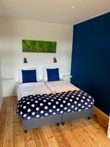 雷讷瑟Studio appartement 1nul9Noord的一间卧室配有一张蓝色墙壁的床