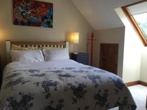 恩尼斯Eden Cottage Countryside Retreat的卧室配有一张床,墙上有十字架