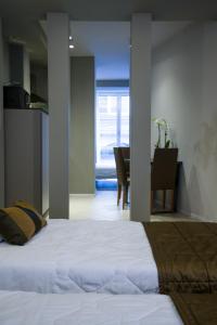 博洛尼亚Appartamenti Astoria的一间带白色床的卧室和一间用餐室