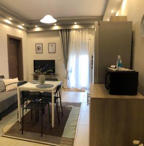 科扎尼Xenia_Apartments A6的厨房以及带桌椅的起居室。