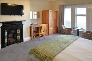 哈特尔普尔航海酒店的一间卧室配有一张带壁炉和电视的床。