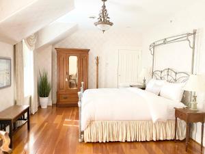 兰利Princess and the Pea Hotel的卧室配有白色的床,铺有木地板