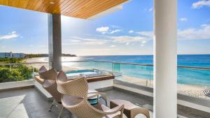 Meads BayTranquility Beach Anguilla Resort的阳台配有椅子,享有海景。