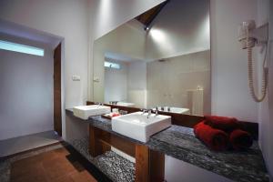 吉利特拉旺安ASTON Sunset Beach Resort - Gili Trawangan的一间带两个盥洗盆和大镜子的浴室