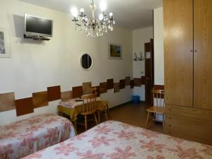 奥斯塔博赛若尔酒店的客房设有两张床、一张桌子和一个吊灯。