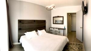 萨摩斯Hotel Anthousa的卧室配有白色的床和木制床头板