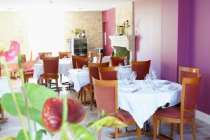 Saint-Pey-de-CastetsLogis- Hôtel Spa Restaurant l'Epicurial的餐厅设有白色的桌椅和紫色的墙壁