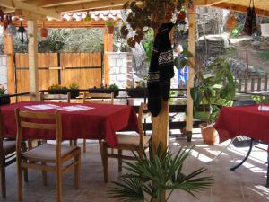 奥赫里德里斯托宾馆的庭院配有桌椅和红色桌布