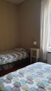 Saint-Germain-des-BoisGîte Le Campagnard的一间卧室设有两张床和一张桌子及窗户
