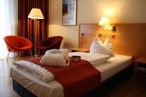 什未林Boulevard Hotel Altstadt Schwerin的酒店客房,配有一张床和两把椅子