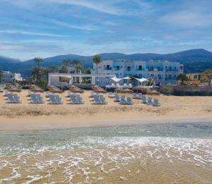 玛利亚爱格里海滩公寓式酒店的海滩上摆放着椅子,酒店背景