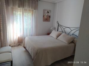 普拉森西亚Apartamento Dacosta的白色的卧室设有床和窗户