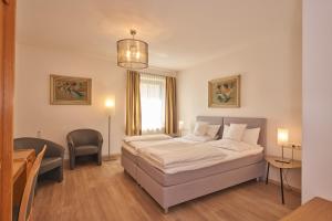 劳茵戈恩德瑞穆罕兰德娜酒店的卧室配有1张床、1张桌子和1把椅子