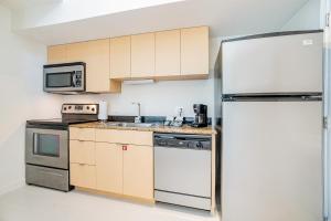 迈阿密Doral Inn & Suites Miami Airport West的厨房配有冰箱和水槽