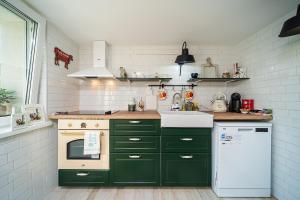 阿尔贝纳Casa de la Mare - Albena的厨房配有绿色橱柜和白色冰箱