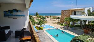 通贝斯Zorritos Apartment的享有游泳池和海滩的上方景色