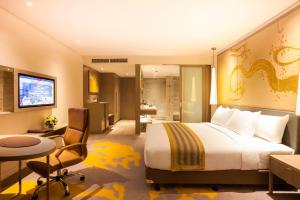 万象万象皇冠假日酒店的酒店客房设有一张大床和一张书桌。
