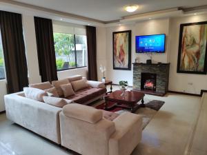 基多Hospedaje en Quito Norte, Apartamento & Suite independientes的带沙发和壁炉的客厅