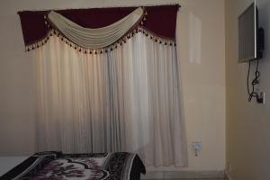 拉瓦尔品第Hotel Sky INN的一间卧室配有床和带窗帘的窗户