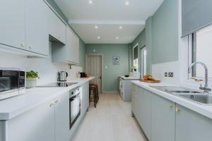 拉格比BRAND NEW TOWNHOUSE IN RUGBY的厨房配有白色的台面和绿色的墙壁