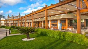 拉瑞拜亚拉腊酒店 的一座大建筑,在院子里种有棕榈树