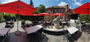 蒙斯蒙特克里斯托酒店的一个带喷泉、桌子和红色遮阳伞的庭院