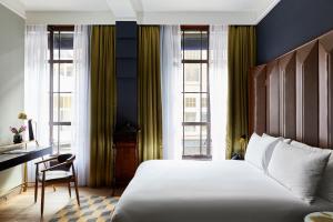 海牙海牙英迪格酒店 - 努儿登堡宫的卧室配有一张床、一张书桌和窗户。
