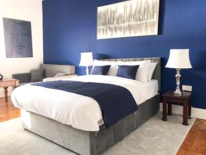 海斯廷斯The Bank Hotel & Bistro的一间卧室设有一张蓝色墙壁的大床
