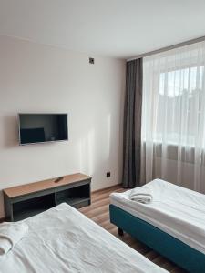 维尔纽斯"AVA" apgyvendinimo įstaiga的酒店客房设有两张床和一台平面电视。
