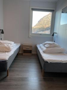 欣萨维克Hardangerpark AS的带窗户的客房内的两张床