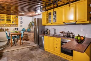 安吉斯乔治亚斯尼拉Villa Evridiki by Pelion Esties的厨房配有黄色橱柜和桌子