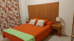 巴列埃尔莫索Casa Las Dionisias的一间卧室配有带橙色和绿色床单的床