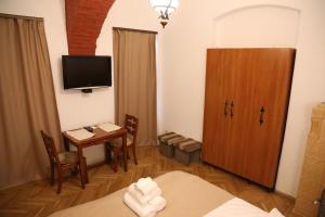 布拉索夫Residence Krone的小房间设有桌子和电视,还有一间房间