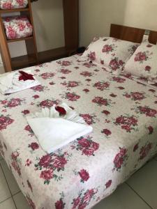 瓜鲁柳斯Ipê Guaru Hotel的一张床上的白色毯子,上面有鲜花