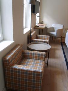 海德堡施努克罗什酒店的客厅配有两张沙发和一张桌子