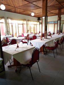 布琼布拉KING'S CONFERENCE CENTRE的用餐室配有白色的桌子和红色的椅子