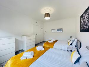 格拉斯哥Cardonald Central的卧室设有2张床和白色的墙壁。
